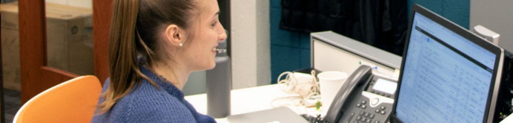 A student checking her email at a desktop computer